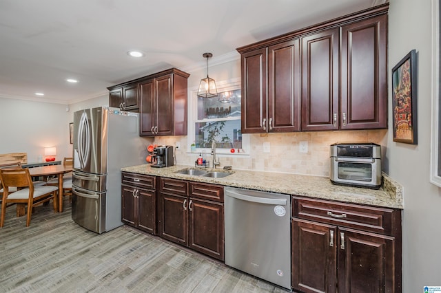 kitchen with sink, ornamental molding, decorative light fixtures, light hardwood / wood-style floors, and stainless steel appliances