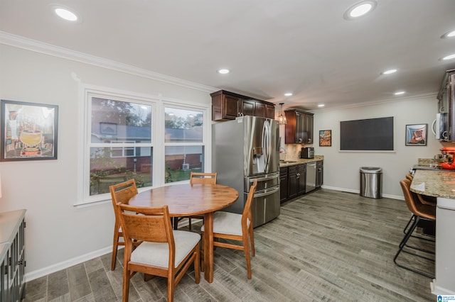 dining area featuring hardwood / wood-style flooring, ornamental molding, and sink