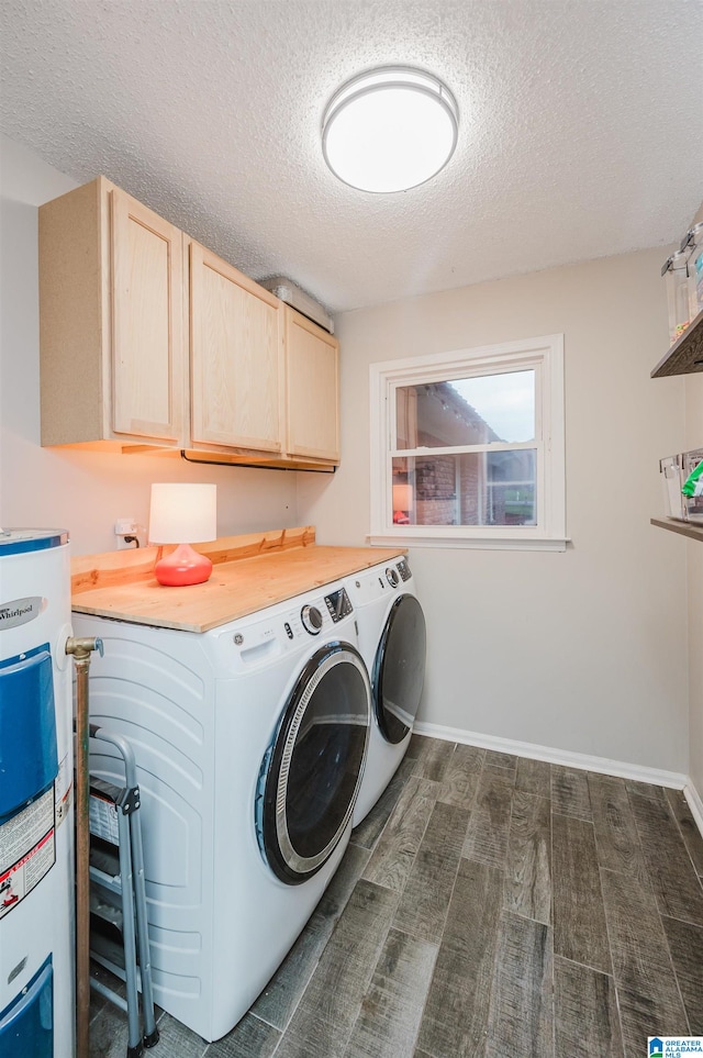 washroom featuring cabinets, a textured ceiling, dark wood-type flooring, water heater, and washer and dryer