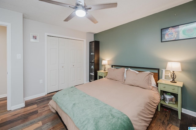 bedroom featuring a textured ceiling, dark hardwood / wood-style flooring, a closet, and ceiling fan