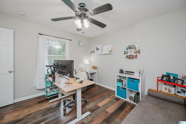 office space with a textured ceiling, ceiling fan, and dark wood-type flooring