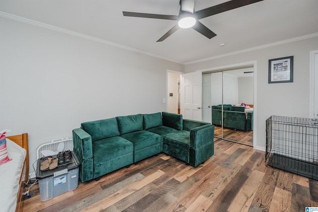 living room featuring ceiling fan, ornamental molding, and hardwood / wood-style flooring