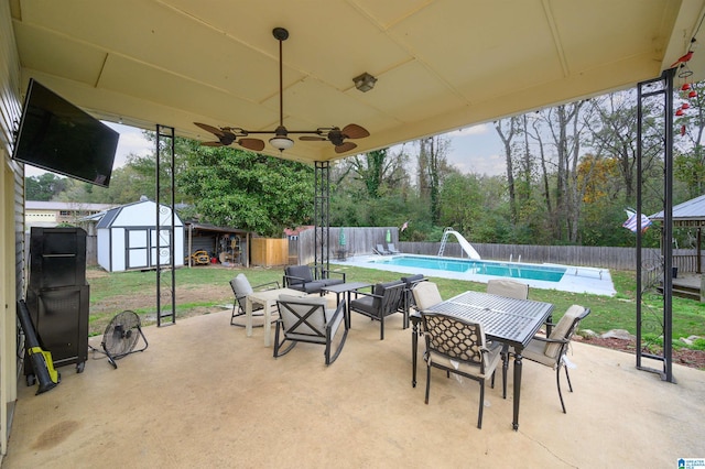 view of patio / terrace with a fenced in pool and a storage shed