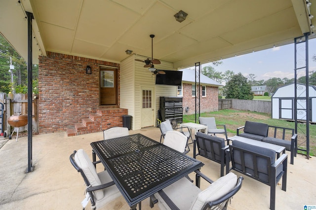 view of patio / terrace with an outdoor living space, ceiling fan, and a storage unit