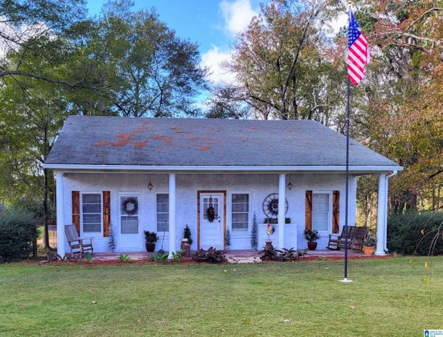 ranch-style house featuring covered porch and a front yard