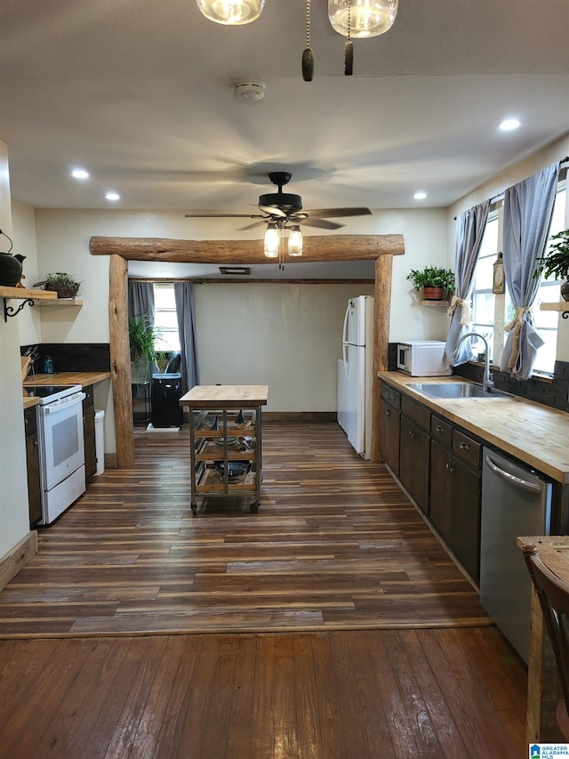 kitchen with plenty of natural light, sink, white appliances, and dark wood-type flooring