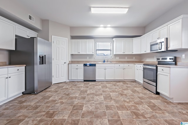 kitchen with white cabinets, sink, and stainless steel appliances