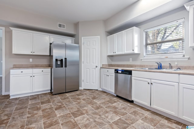 kitchen with white cabinets, appliances with stainless steel finishes, and sink