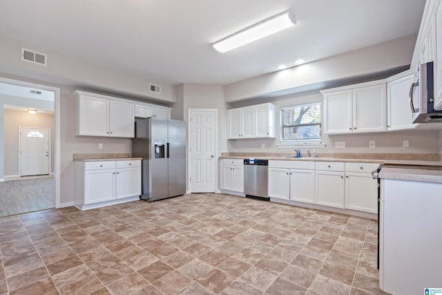 kitchen with sink, white cabinets, and appliances with stainless steel finishes