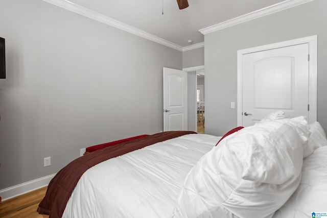 bedroom with hardwood / wood-style floors, ceiling fan, and crown molding