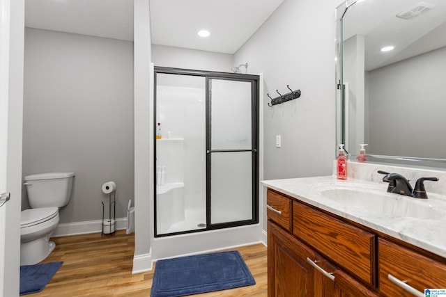 bathroom featuring vanity, wood-type flooring, an enclosed shower, and toilet