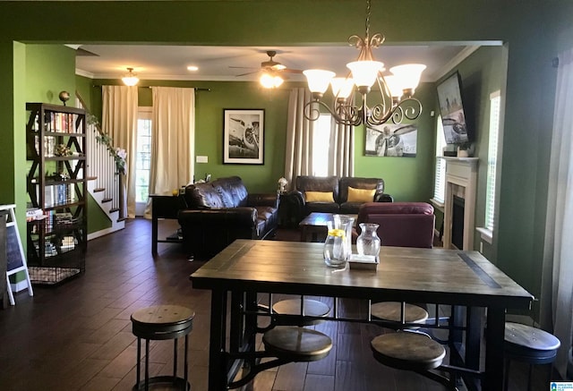 dining room featuring ceiling fan with notable chandelier, dark hardwood / wood-style floors, and ornamental molding