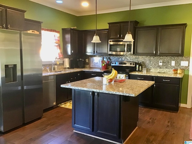 kitchen with pendant lighting, a center island, stainless steel appliances, and dark wood-type flooring