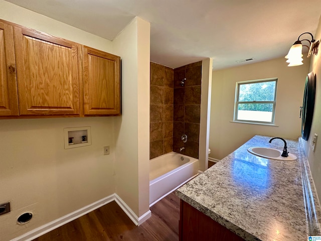 full bathroom with vanity, toilet, wood-type flooring, and tiled shower / bath