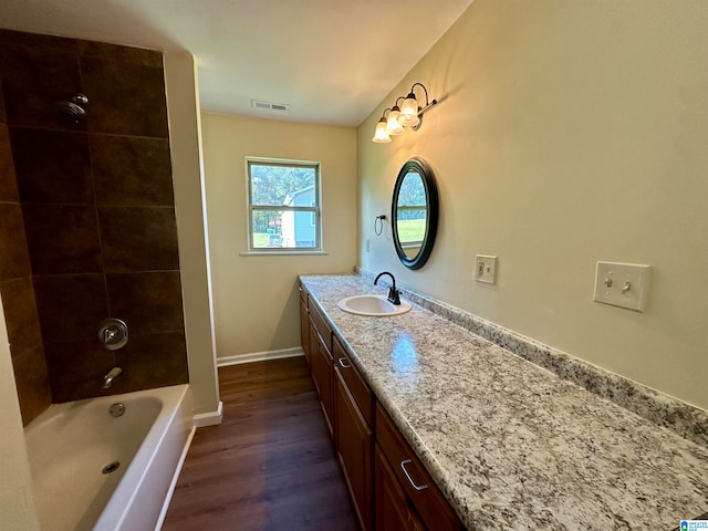 bathroom featuring vanity, tiled shower / bath combo, and hardwood / wood-style flooring