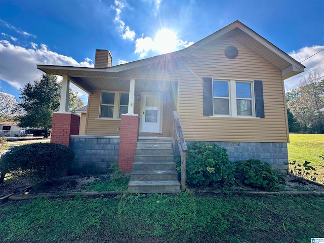 view of front of property with a front yard and covered porch