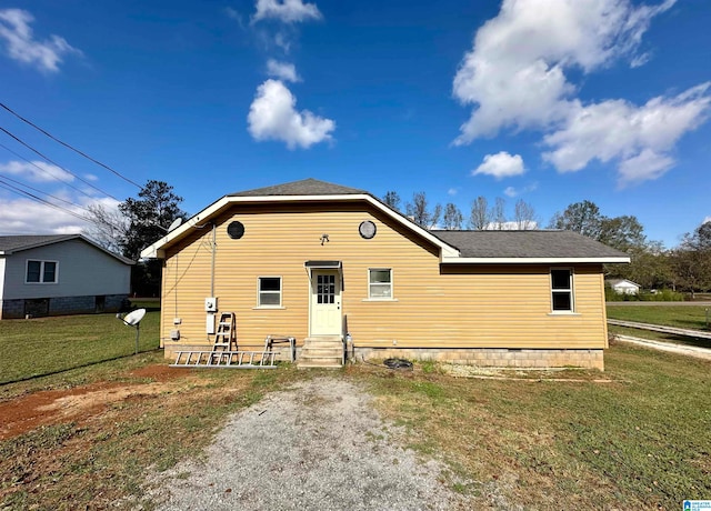 rear view of property featuring a lawn