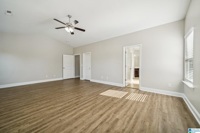 interior space with ceiling fan, wood-type flooring, ensuite bathroom, and lofted ceiling