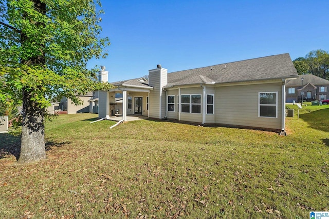 back of house featuring a lawn, a patio area, and central AC