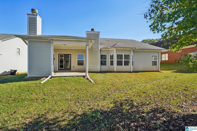 rear view of property featuring a lawn and a patio area