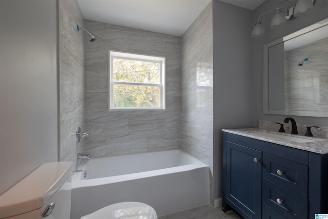 full bathroom with vanity, tiled shower / bath, and toilet