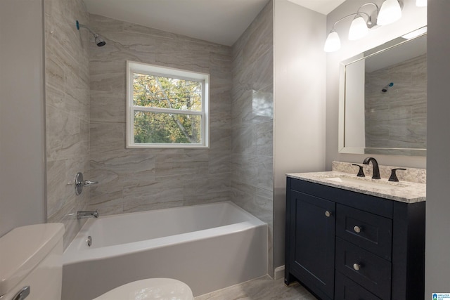 full bathroom with toilet, vanity, and tiled shower / bath