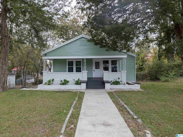 bungalow-style home with a front yard and covered porch