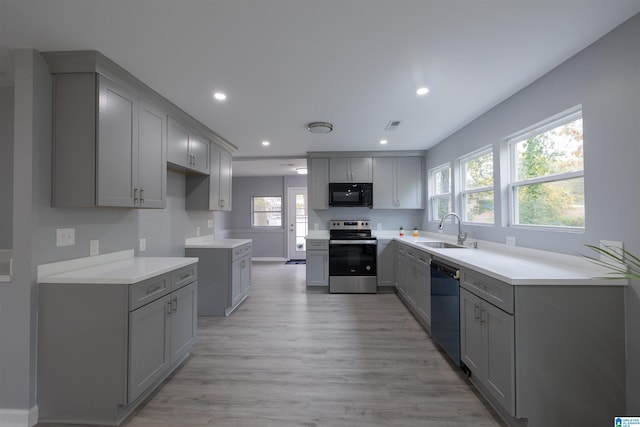 kitchen featuring black appliances, gray cabinetry, and sink