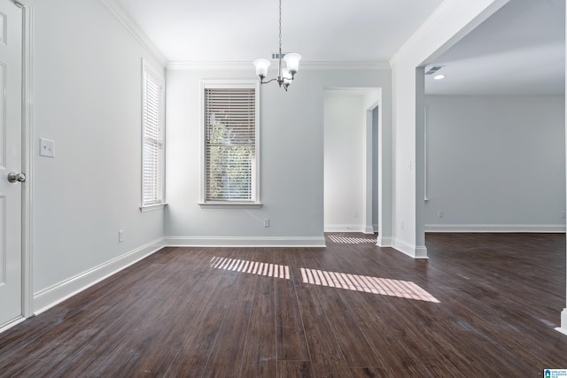 spare room with dark hardwood / wood-style floors, crown molding, and a notable chandelier