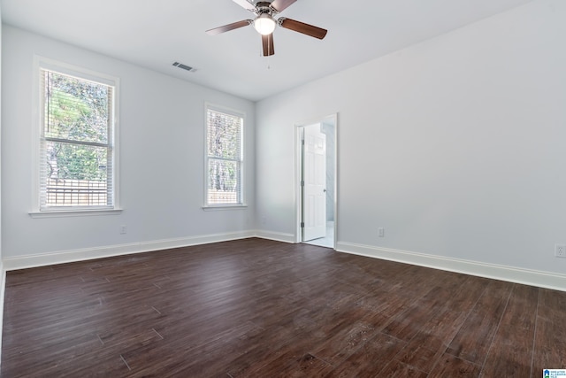 spare room with ceiling fan, dark wood-type flooring, and a healthy amount of sunlight