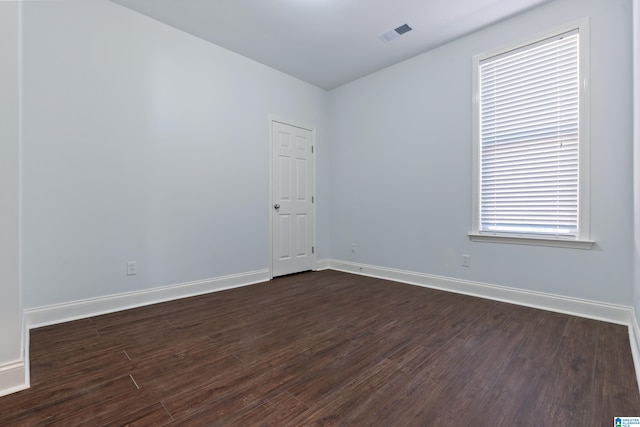 empty room with dark hardwood / wood-style flooring