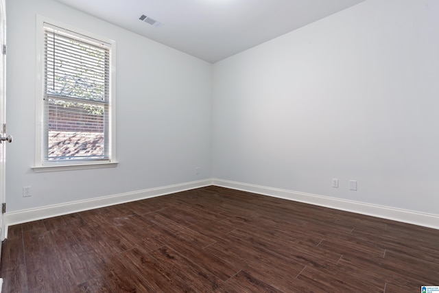 spare room with dark hardwood / wood-style floors and plenty of natural light