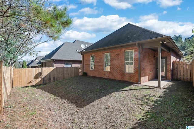 back of house with a yard and a patio