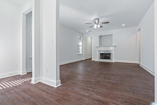 unfurnished living room with a fireplace, dark hardwood / wood-style floors, and ceiling fan