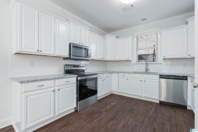 kitchen with light stone countertops, white cabinetry, sink, dark hardwood / wood-style flooring, and appliances with stainless steel finishes