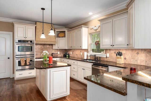 kitchen featuring dark wood-type flooring, crown molding, hanging light fixtures, a kitchen island, and stainless steel appliances