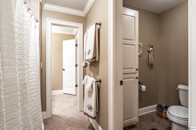 bathroom with tile patterned floors, toilet, and crown molding