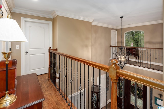 corridor featuring hardwood / wood-style flooring, a notable chandelier, and crown molding