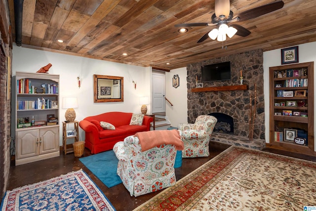 living room with ceiling fan, wooden ceiling, and a fireplace