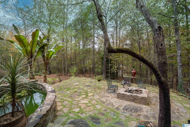 view of yard featuring an outdoor fire pit and a patio