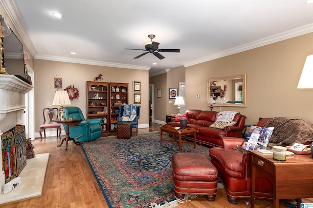 living room with ceiling fan, ornamental molding, a premium fireplace, and light hardwood / wood-style flooring