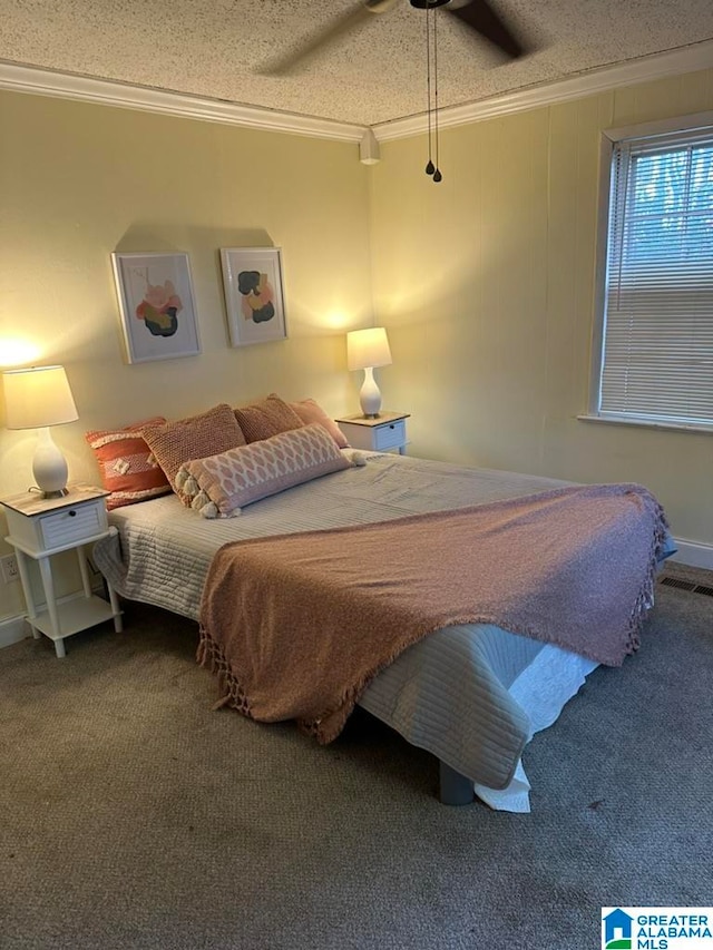 bedroom featuring ceiling fan, carpet floors, a textured ceiling, and ornamental molding