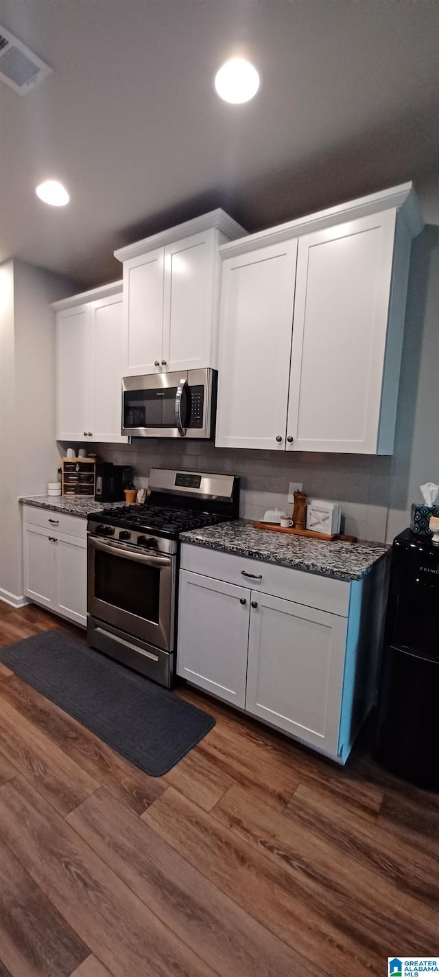 kitchen featuring visible vents, white cabinetry, and stainless steel appliances