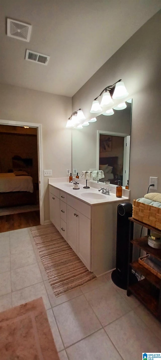 bathroom featuring double vanity, visible vents, a sink, and tile patterned floors