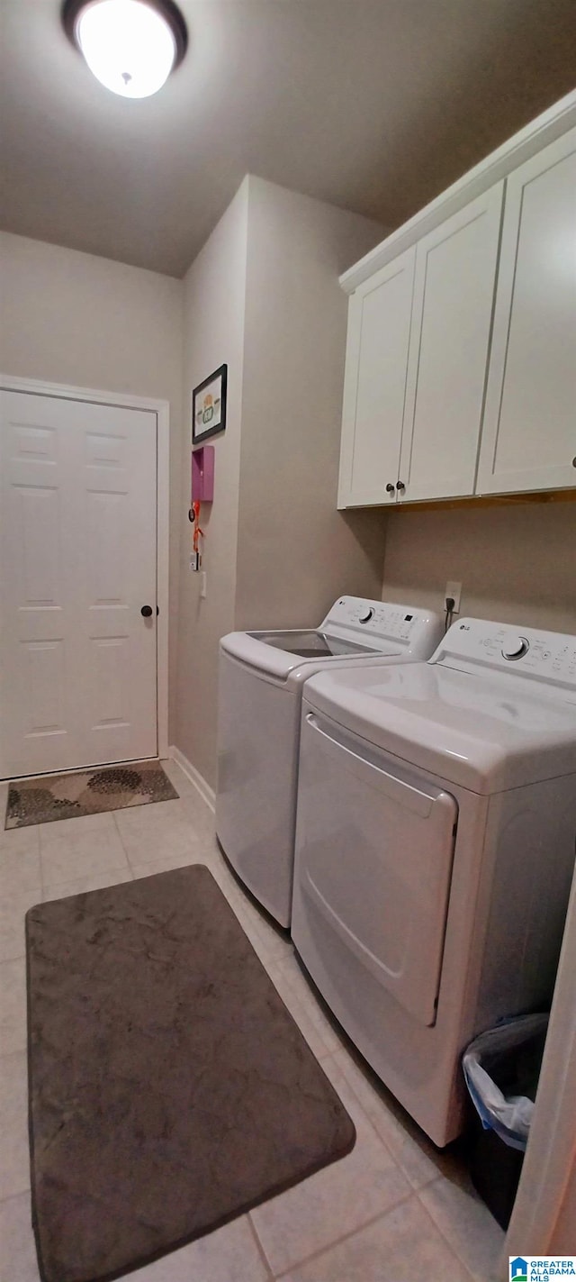 laundry room with cabinet space, washing machine and clothes dryer, and light tile patterned floors