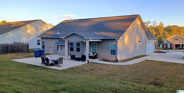 back of house featuring a shingled roof, a patio area, fence, and a lawn