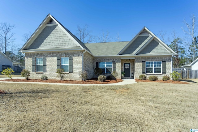 craftsman house with a front yard and brick siding