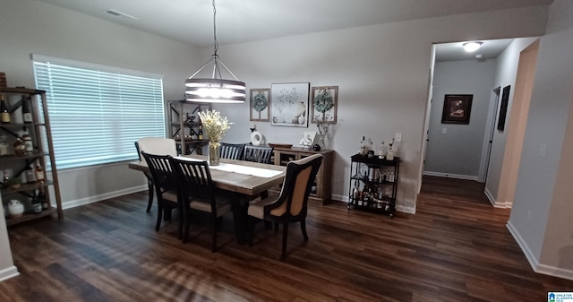 dining space featuring dark wood-style flooring and baseboards