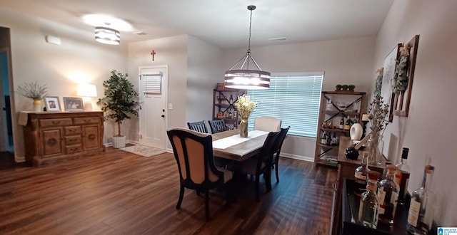 dining space with dark wood-style floors, baseboards, and visible vents