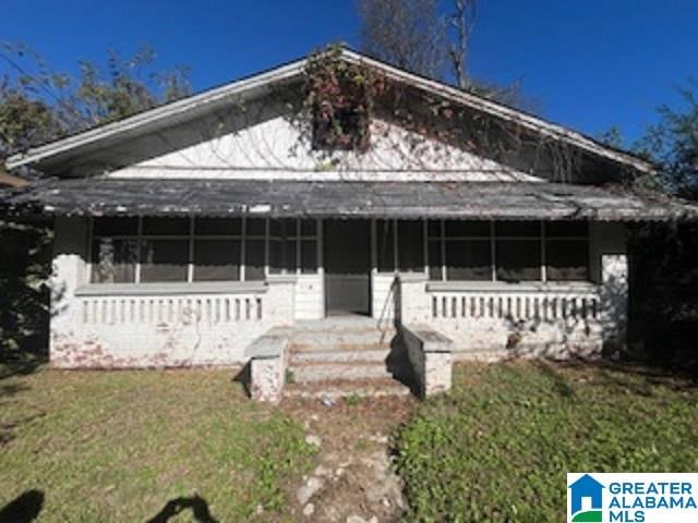 view of front of property featuring covered porch and a front lawn